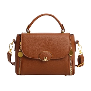 Brown litchi grain satchel with gold M buckle and adjustable crossbody strap