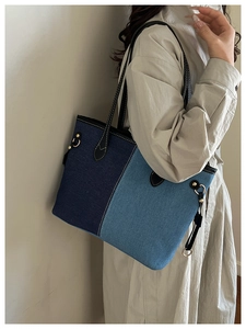 Détail de couture contrastée sur la lanière en cuir et cabas en jean patchwork