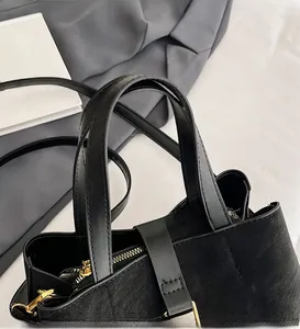 Detail of the black leather bucket bag with gold zipper and comfortable handles