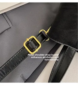 Detailed macro view of the golden metal buckle on a black leather adjustable shoulder strap