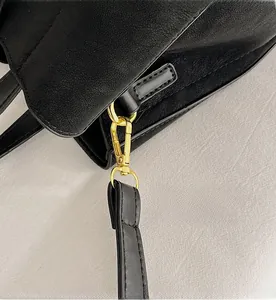 Detailed macro view of high-quality golden metal hook on black leather bucket bag strap