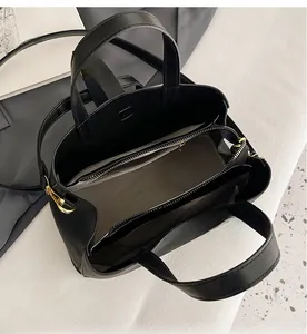 Interior of the black tote bag showing multiple compartments and golden zippers
