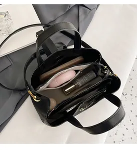 Interior view of black leather bucket bag showing large capacity with personal items