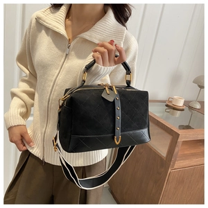 Detail of black quilted Boston bag with suede finish and striped wide shoulder strap