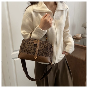 Detail of leopard print crossbody bag with gold rivets and quilted leather on a model