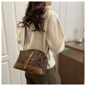 Detailed back view of leopard print suede crossbody bag with brown leather stitching