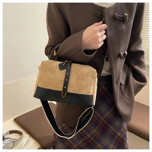 Detail of vintage suede pillow bag featuring diamond stitching and gold hardware accents