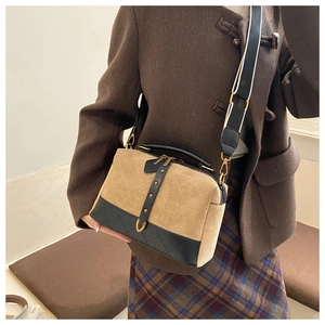 Detail of khaki faux suede crossbody bag with diamond stitching and black leather trim