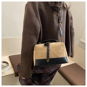 Detail of vintage suede crossbody bag with quilted pattern and elegant stitching