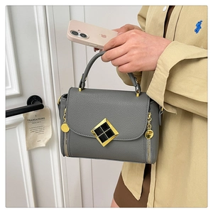 Détail du sac à main gris motif litchi avec fermoir doré et poignée en similicuir