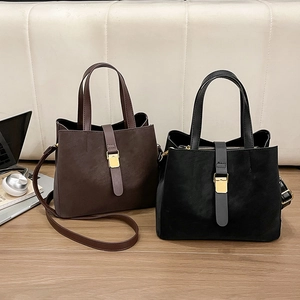 Minimalist large bucket bags in black and brown faux suede with golden hardware accents
