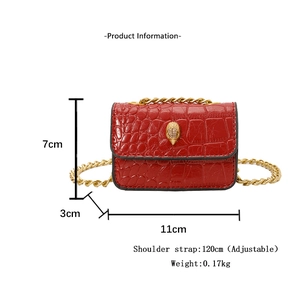 Détail du micro sac rouge effet croco avec tête d'aigle sertie et chaîne dorée chic