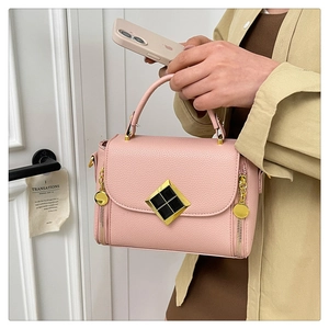 Détail du sac à main en cuir grainé rose avec fermoir doré et pampille de fermeture