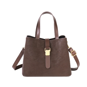 Vintage dark brown bucket bag with gold buckle hardware and adjustable strap on white background