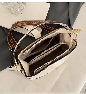 Internal structure of the beige bucket bag showing compartments and jacquard strap