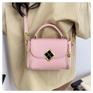 Détail du sac à main rose en cuir grainé avec fermoir doré et bandoulière réglable