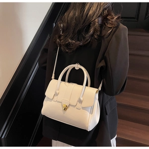 Close-up of beige PU leather tote bag with elegant gold metal buckle and dual handles