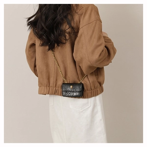 Mini sac noir motif crocodile avec chaîne dorée porté en bandoulière par un mannequin