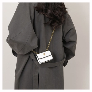 Détail du mini sac blanc à texture crocodile avec chaîne dorée et fermoir tête d'aigle