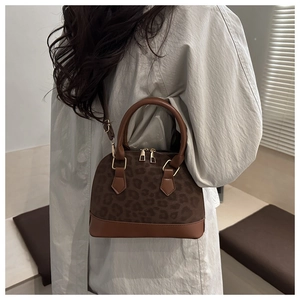 Model wearing a vintage leopard print seashell handbag with brown leather strap