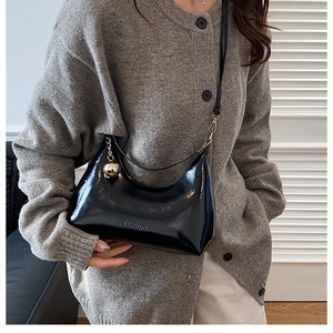 Sac demi-lune tendance en cuir verni noir avec détail de charme sphérique doré