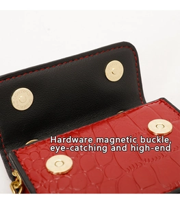 Détail du sac rouge à texture crocodile et boucles magnétiques dorées