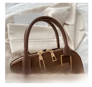 Detail of comfortable round leather handle and smooth gold dual zippers on leopard shell bag