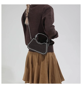 Détail de la poignée argentée gravée et des rivets sur le sac box noir tendance