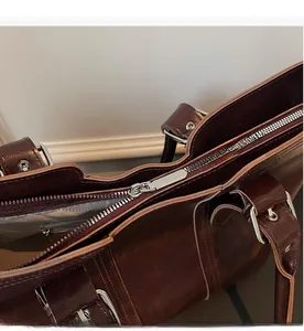 Detail of smooth silver zipper and interior lining of the vintage brown leather tote bag