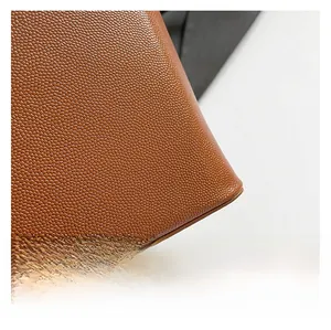 Detail of brown bucket bag showing lychee pattern texture and high-quality oil edge finish