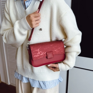 Elegante borsa a tracolla rossa con patta testurizzata e finitura opaca su modella