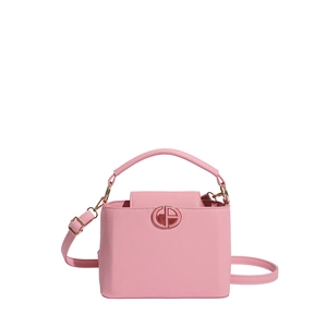 Pink textured bucket bag with top handle and gold logo detail in a studio shot