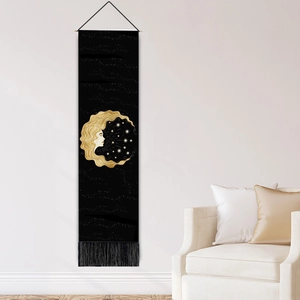 Wandteppich mit Mondgöttin, goldenen Sternenmustern und schwarzen Quasten an weißer Wand