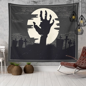 Detail of Halloween tapestry with zombie hand and full moon over a graveyard scene