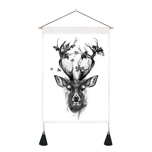 Close-up of modern black and white deer art tapestry with wooden pole and tassels