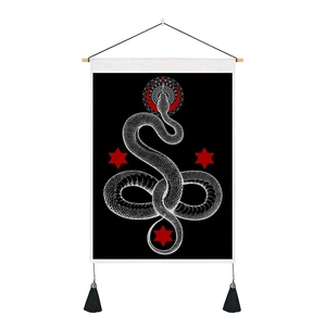 Detail of snake tapestry with red stars moon and black tassels hanging on a wooden rod