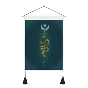 Detail of mystical wall tapestry featuring a green snake, moon, and black tassels
