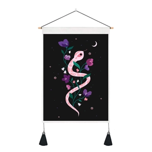 Detail of bohemian snake tapestry with floral patterns, wooden rod, and black tassels