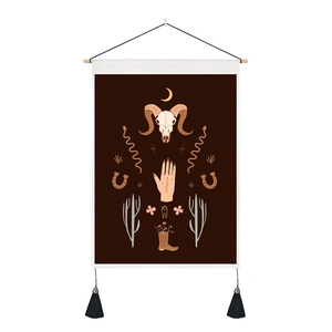 Dettaglio di arazzo boho con teschio di ariete, luna e cactus con nappe nere decorative
