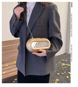Detail of champagne gold capsule clutch with mirror insert and fine gold chain strap