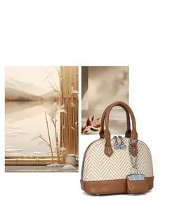 Detail of woven beige shell bag with brown leather handles and silver-tone metal hardware