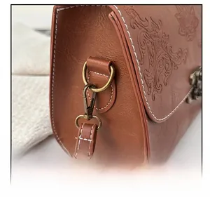 Detailed macro of vintage embossed leather bag strap with retro bronze hardware and stitching