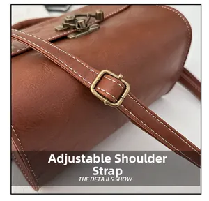 Detail view of adjustable shoulder strap with vintage bronze metal buckle on brown bag