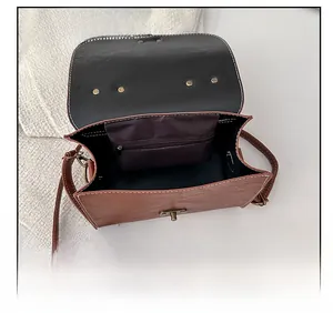 Detail of brown faux leather bag showing interior lining, zipper pocket and vintage lock