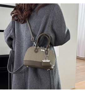 Detail of vintage patchwork shell bag showing olive leather and tweed texture on model