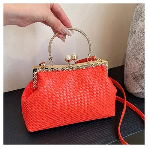Detail of red woven shell bag featuring gold floral rhinestone clasp and pearl accents