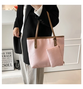 Detail of pink woven texture tote bag with brown straps and matching small pouch