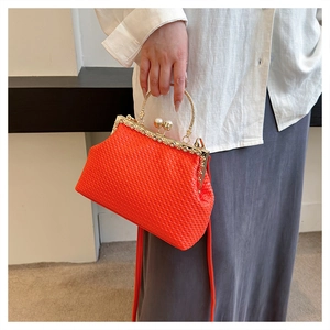 Detail of orange woven shell bag with pearl metal handle and vintage frame