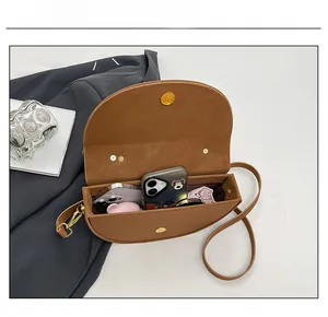 Internal capacity of brown saddle bag showing space for phones and essentials