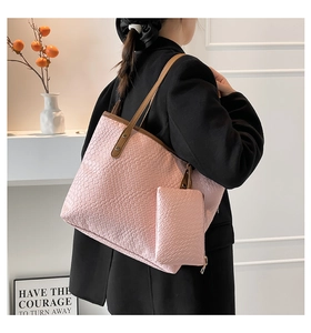 Dettaglio della borsa tote rosa intrecciata con pochette coordinata e manici in cuoio